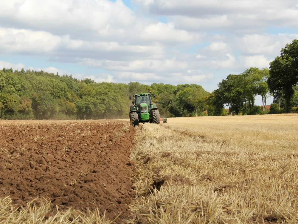 Modern tractor working through a cultivated agricultural field