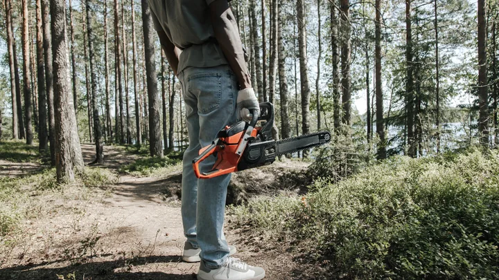 Forestry worker carrying professional cutting equipment