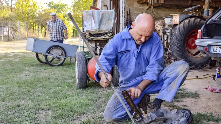 Agricultural mechanic maintaining farm equipment