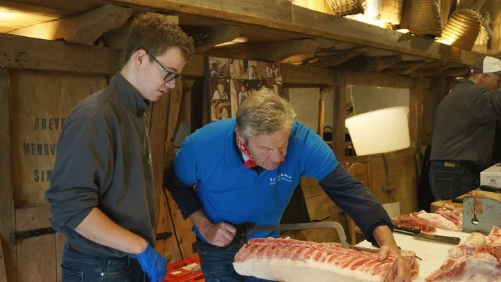 Skilled butchers preparing meat in a professional workspace